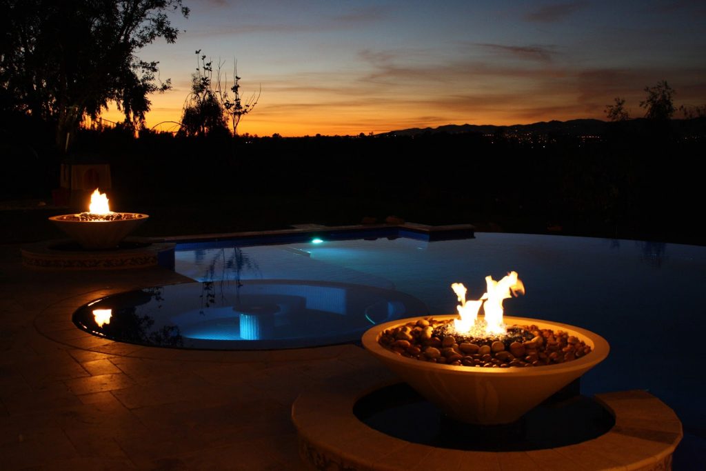 Fire features by a vanishing edge swimming pool in the sunset