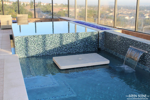 an infinity-edge spa in a contemporary pool with a built-in table