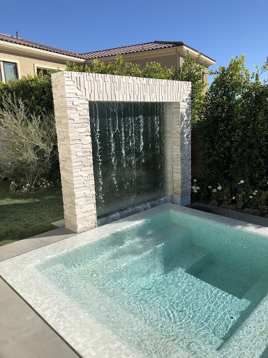 a sleek waterfall feature in a contemporary pool design