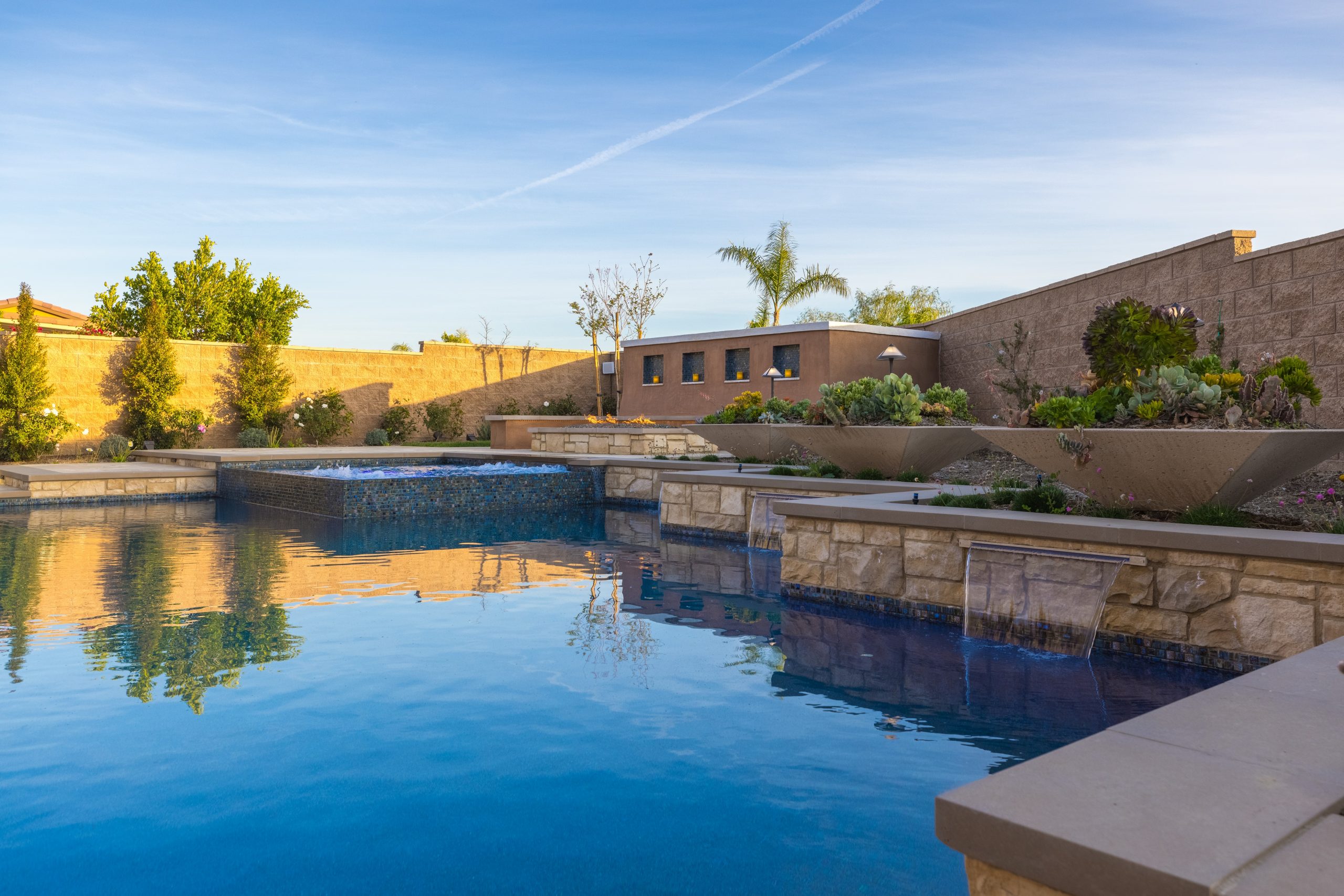 backyard with saving water drought resistant design like landscaping and low splash waterfalls in the pool